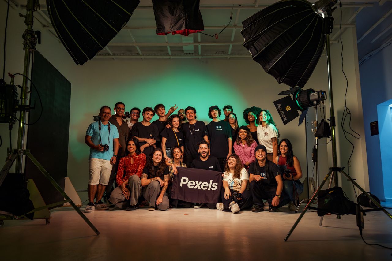 A varied assembly of adults posing within a professional photo studio.