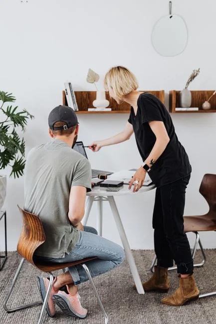 A stylish desk setup featuring a digital tablet, keyboard, camera, and plant, ideal for creative work.